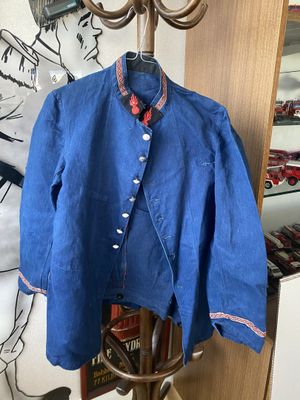 une veste bleue posée sur un portant devant un mur orné d'un dessin