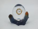 a small glass clock sitting on top of a table