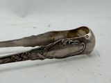 a spoon and tonget sitting on a white surface