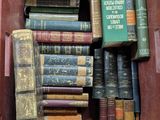de nombreux livres anciens dans une boîte rouge posée sur la table