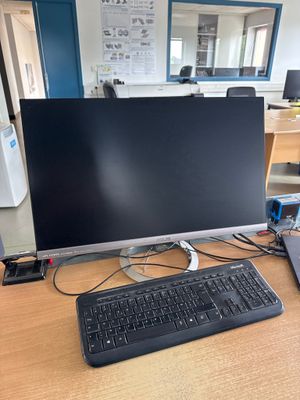 a computer monitor and keyboard on a desk in an office