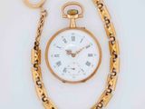 a gold pocket watch with roman numerals on it