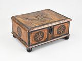 une vieille boîte en bois ornée d'un motif en forme d'étoile sur le devant