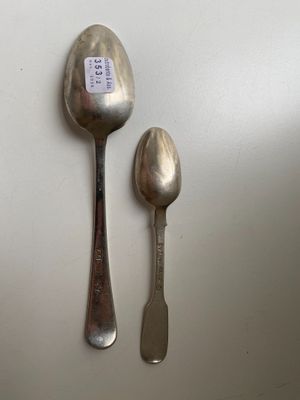two spoons and a spoon rest on a white surface