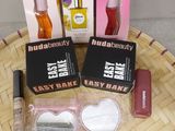 trois boîtes de maquillage et un flacon de liquide posés sur une table