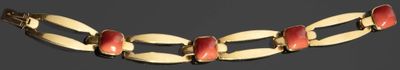 collier composé de perles dorées et de couleur corail sur fond noir