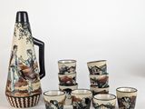 many cups and a pitcher sitting next to each other