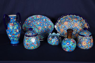 de nombreuses pièces de poterie bleues et vertes disposées sur une table