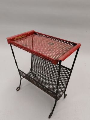 une table en métal rouge sur laquelle est posé un panier