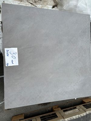 Des dalles de marbre gris sont empilées sur des palettes dans un entrepôt