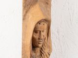 a wooden sculpture of a woman holding a baby