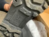 a person holding a pair of black boots in a box