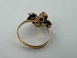 an image of a gold ring with black stones