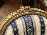 un gros plan d'une chaise dont l'assise est recouverte d'un tissu rayé bleu et blanc