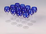 six wine glasses with blue and white designs are lined up on a white surface