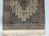 an antique persian rug with a blue background and a gold border