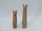 deux figurines de chats assis l'un à côté de l'autre