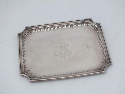 an antique silver tray with a flower design on it
