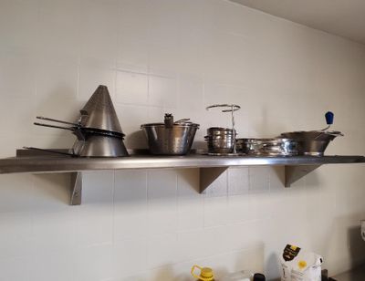 de nombreuses casseroles et poêles sur l'étagère de la cuisine