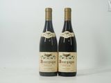 deux bouteilles de vin posées sur une table blanche