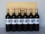six bouteilles de vin rouge sont posées devant une caisse en bois