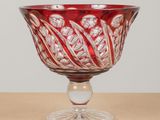 a red glass bowl sitting on top of a table