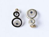 paire de boucles d'oreilles noires et blanches ornées de pierres bleues sur un fond blanc