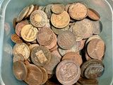 un récipient en plastique rempli d'une multitude de pièces de monnaie posé sur une table