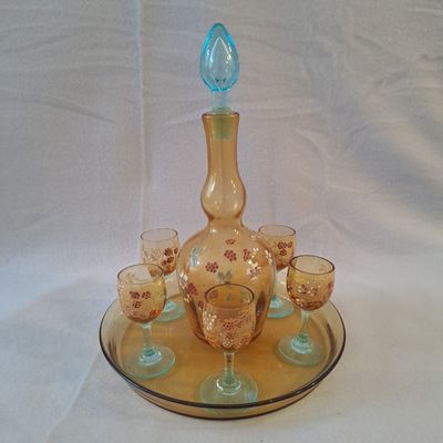 des bouteilles et des verres posés sur un plateau, sur une nappe blanche