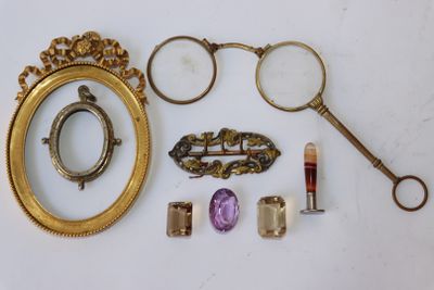 un cadre doré avec un miroir, une paire de lunettes, une paire de ciseaux et une paire de lunettes de vue