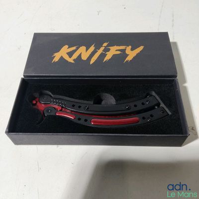 a knife in a black box with a red handle