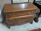 une commode en bois surmontée d'un tableau