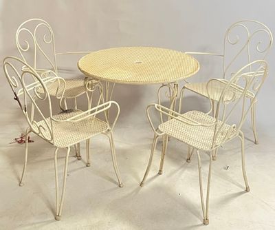 four chairs and a table in a room with a white wall