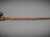 an old pipe with a wooden handle sitting on top of a table