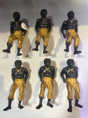 several figurines of black and gold football players on a white surface