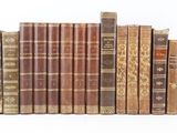 plusieurs vieux livres sont alignés sur une surface blanche