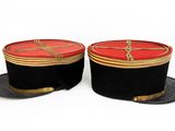 pair of black and red hats with gold trims on top