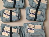 five pairs of blue jeans are laid out on a table