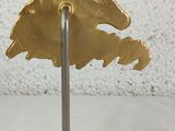 an image of a gold eagle head on a black base