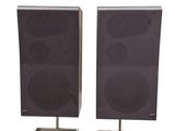 pair of speakers on stands on a white background with a white background