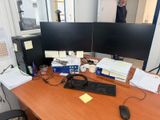 un bureau sur lequel sont posés deux écrans d'ordinateur et un clavier