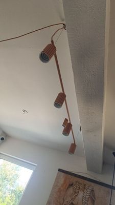 une photo d'un salon avec un ventilateur de plafond et un tableau accroché au mur