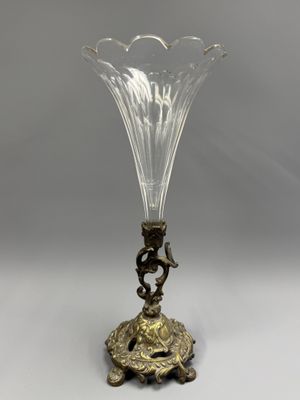 un vase en verre ancien posé sur un socle et orné d'un oiseau