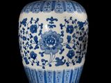 a blue and white vase sitting on a black surface