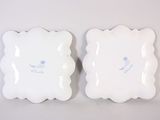 two white plates with blue designs on them sitting on a table