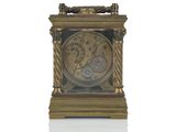 a gold clock that is sitting on a white surface
