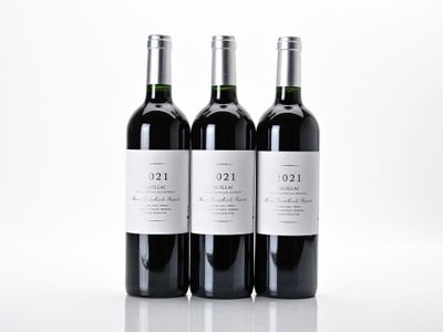 trois bouteilles de vin posées sur une table blanche