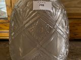 a glass vase with a label on it sitting on the floor