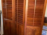 a room with a bed and a closet with wooden shutters