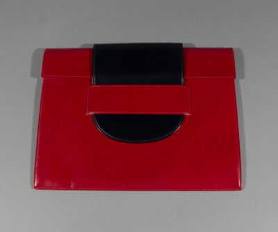 a red purse with a black handle sitting on a table